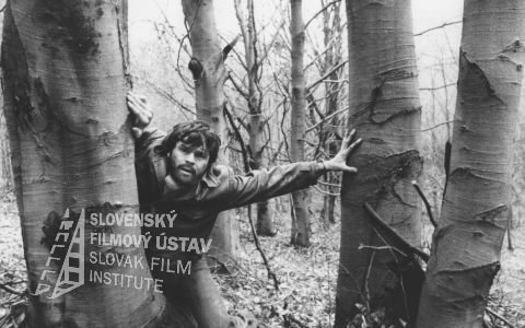 Milan Kňažko (nadporučík Ľudovít Kukorelli) zdroj: skcinema.sk 
V lese o stromy sa opiera Milan Kňažko (nadporučík Kukorelli)