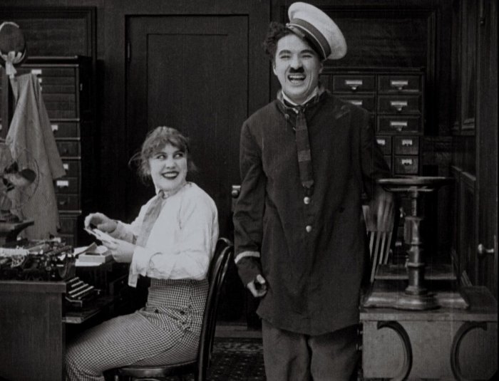 Charles Chaplin (Janitor), Edna Purviance (Stenographer) zdroj: imdb.com