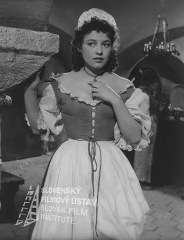 Elena Zvaríková (Rózka) zdroj: skcinema.sk 
Fotografia z filmu Posledná bosorka (1957). V popredí stojí Elena Zvaríková (Rózka)